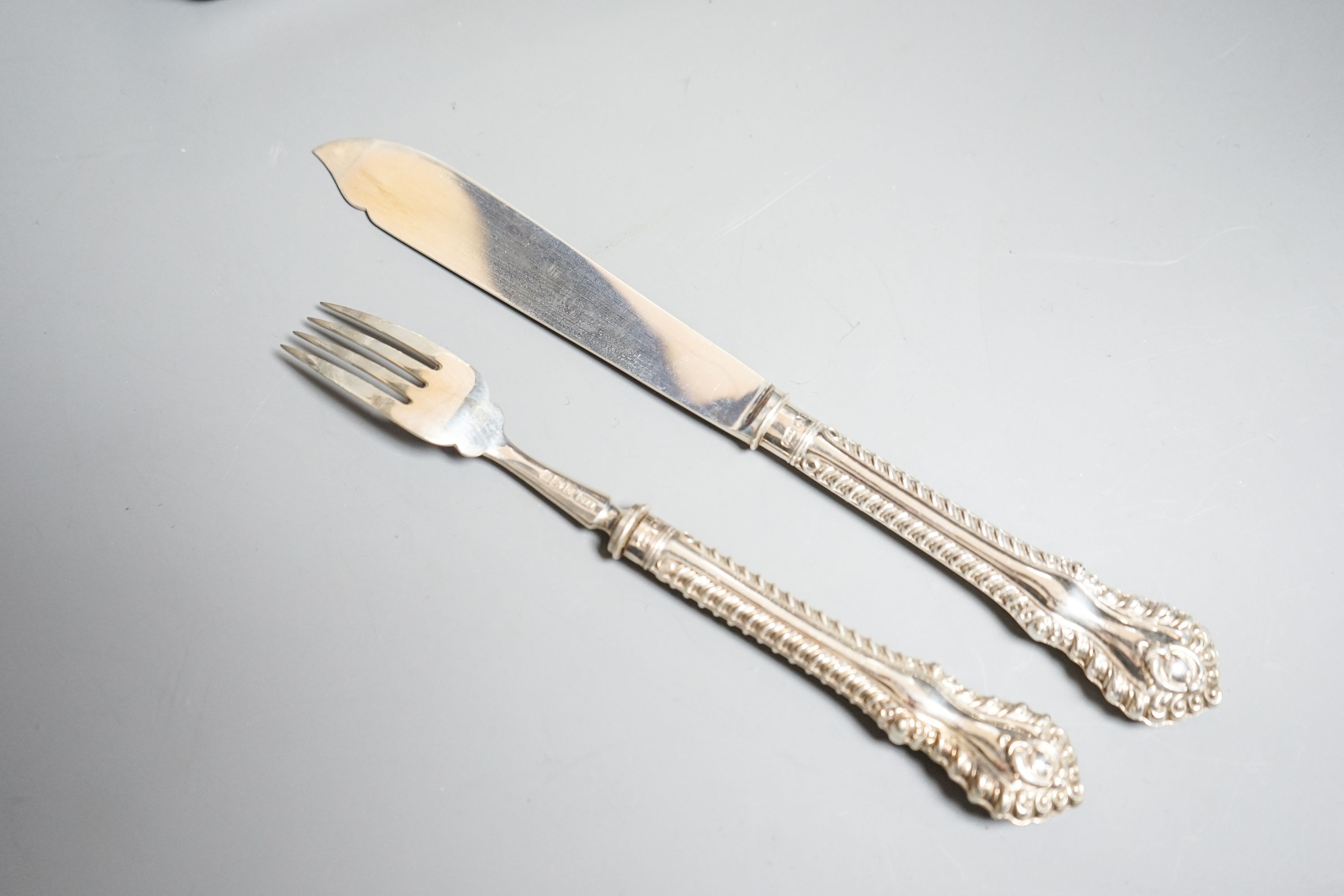 A cased set of twelve pairs of Edwardian silver fish eaters, Allen & Darwin, Sheffield, 1909 (loaded handles)